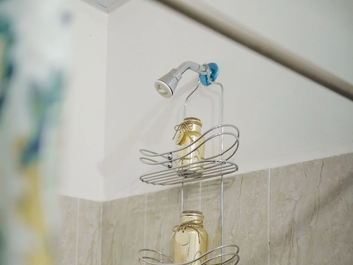 A small bathroom vanity organized with a narrow tray and riser