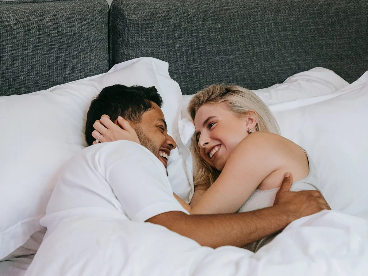 Layered neutral bedding on a shared bed with two different duvet weights