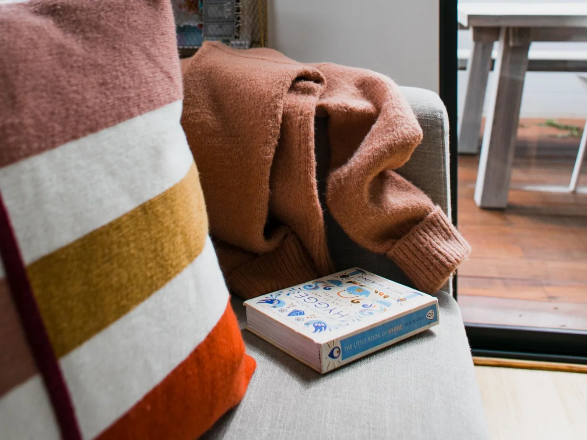 A rented living room softened with a rug, curtains, lamps, and a throw